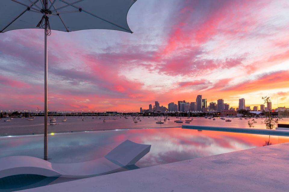 A waterside terrace looking across the bay towards a city skyline at sunset